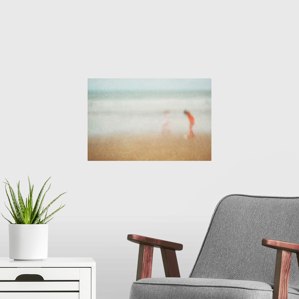 A modern room featuring Giant photograph shows two children playing on a sandy beach at the edge of an ocean.  Photograph...