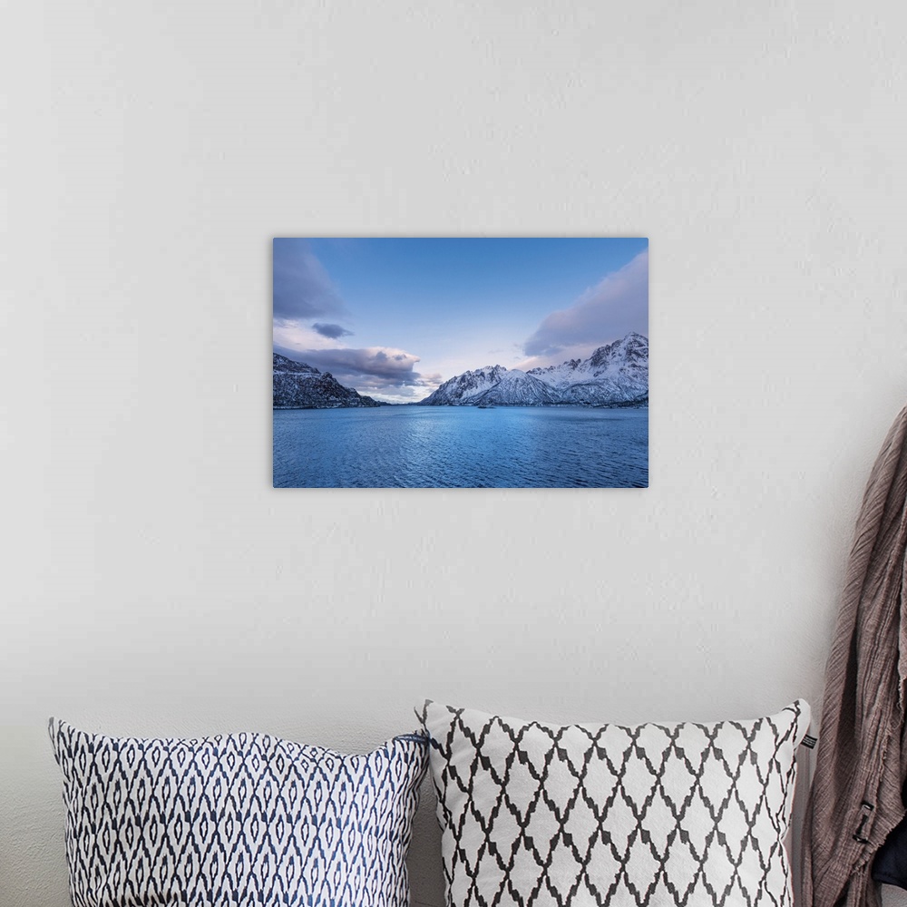 A bohemian room featuring A photograph of mountains seen in from a cross a lake in winter.
