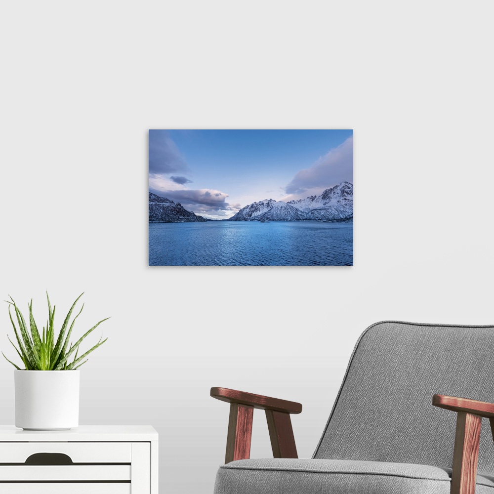 A modern room featuring A photograph of mountains seen in from a cross a lake in winter.