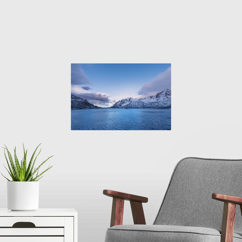 A modern room featuring A photograph of mountains seen in from a cross a lake in winter.