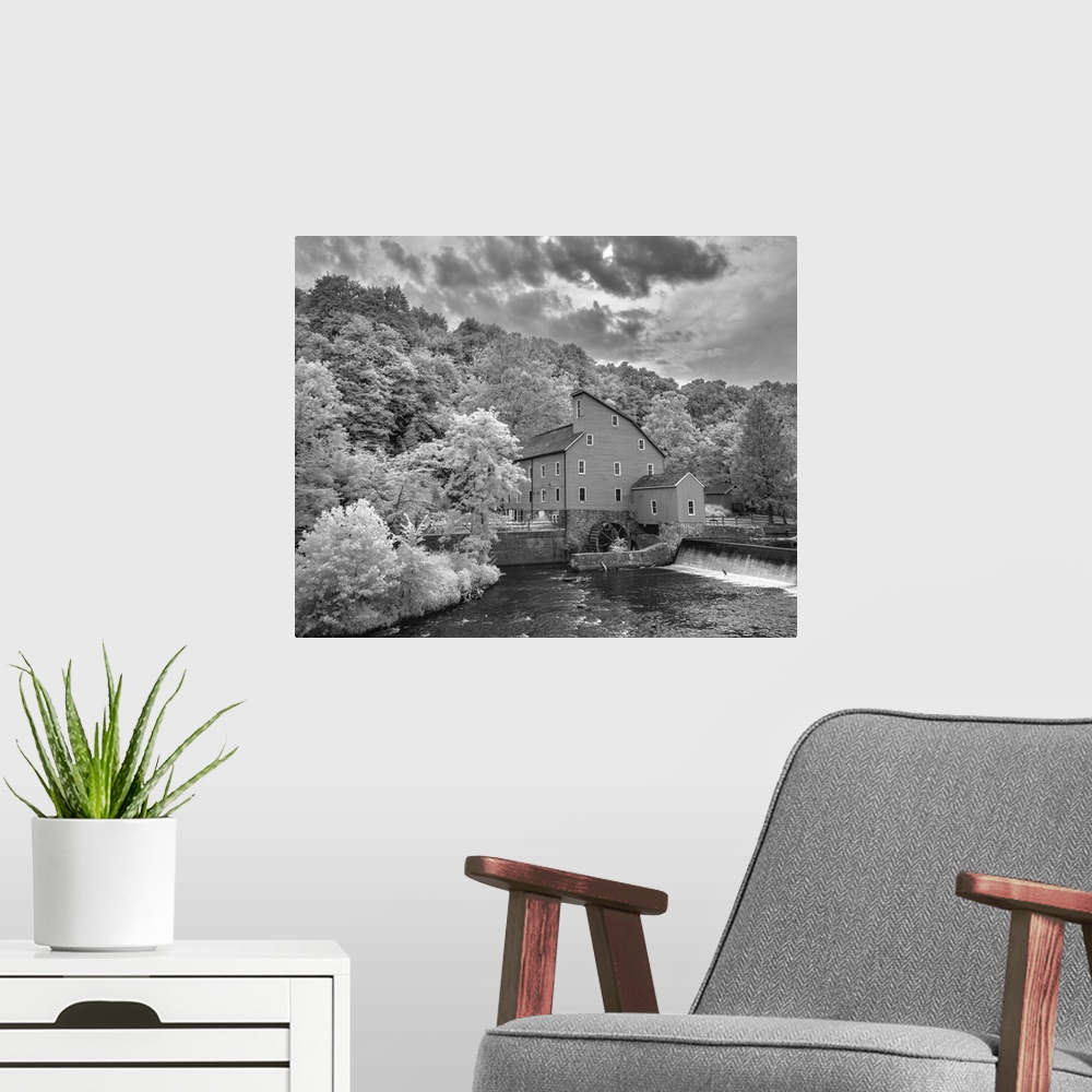 A modern room featuring In this black and white infrared light photograph, dramatic and brightly lit clouds rest over a b...