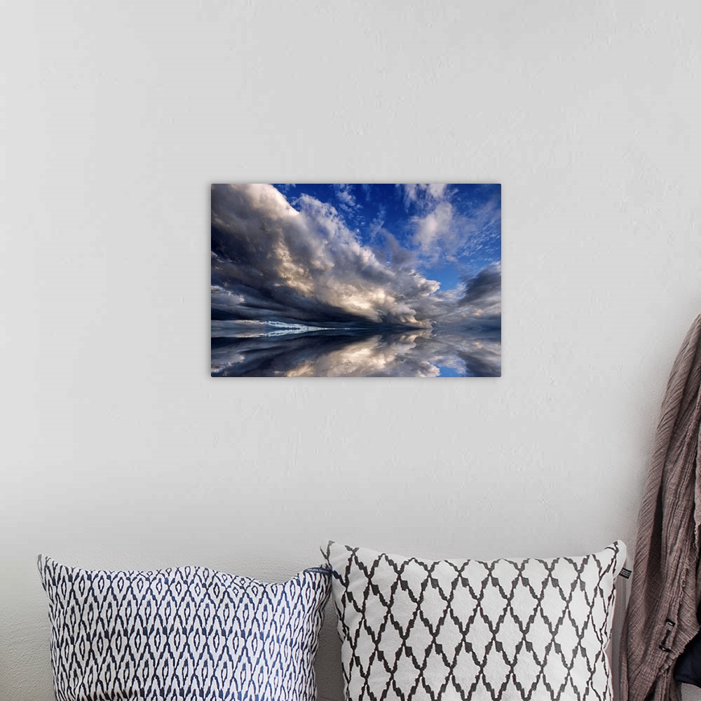 A bohemian room featuring Photograph of cloudy sky that is reflected in the ocean below.