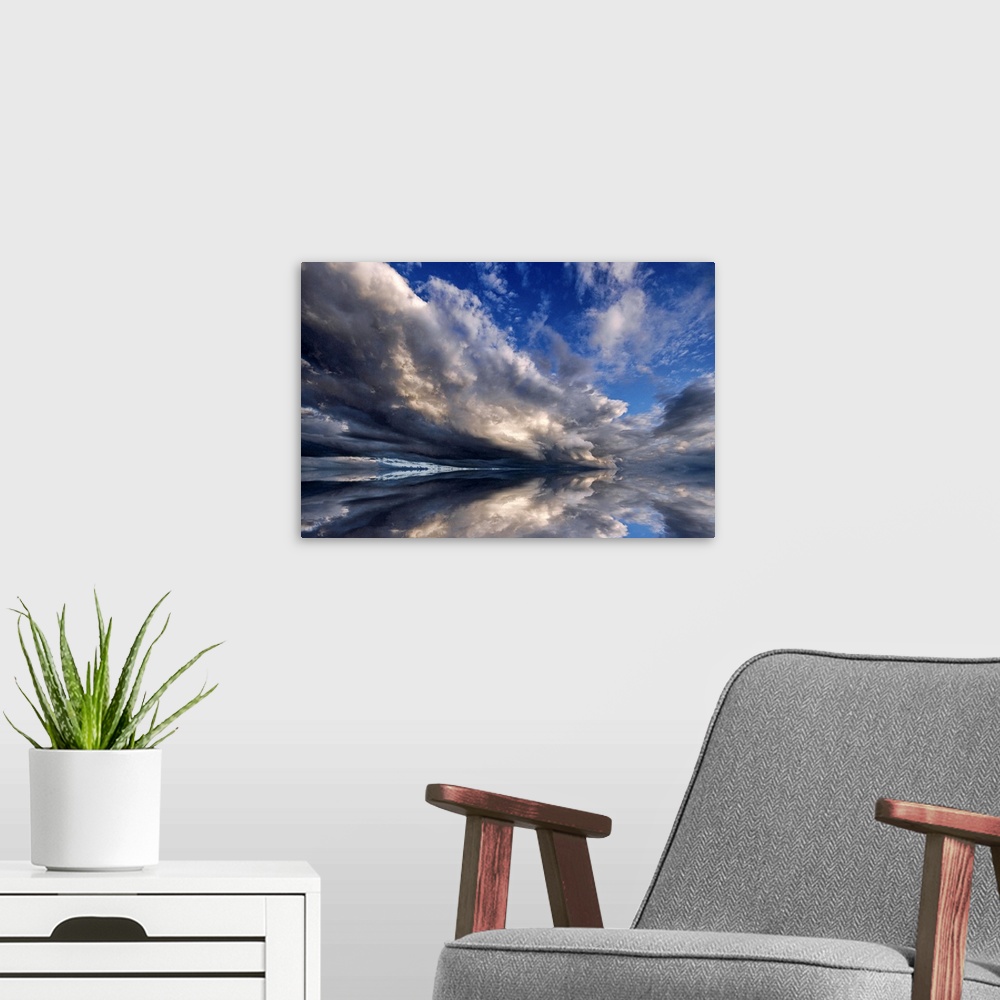 A modern room featuring Photograph of cloudy sky that is reflected in the ocean below.