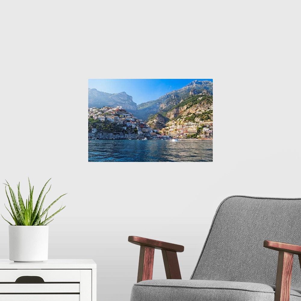 A modern room featuring Fine art photo of the Mediterranean town of Positano nestled in the hills, seen from the ocean.