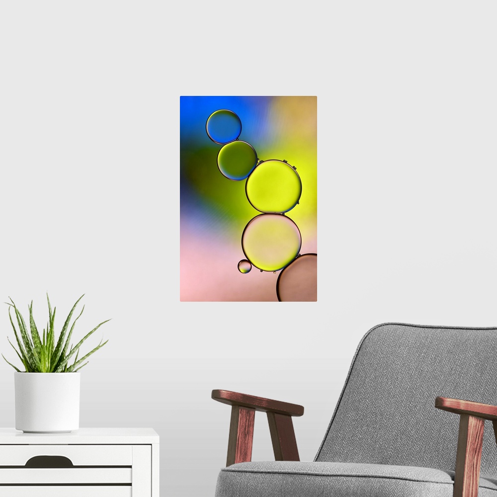 A modern room featuring A stack of large water droplets with tiny droplets on top of them with green, yellow, blue, and p...