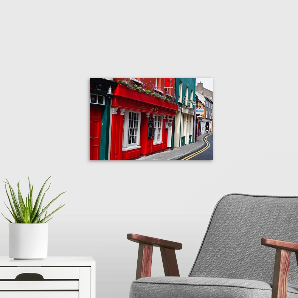 A modern room featuring Colorful buildings in Ireland line a winding street.
