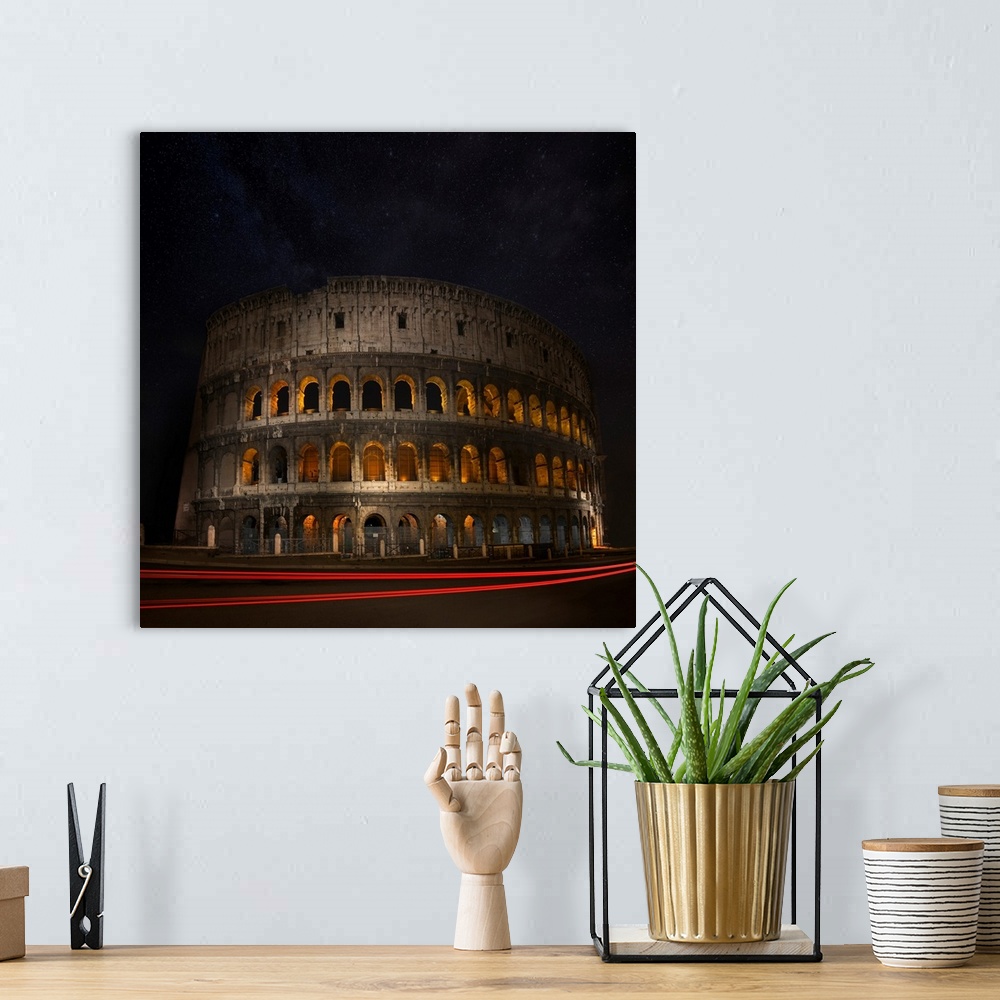 A bohemian room featuring The Colosseum in Rome illuminated at night with light trails from passing cars.