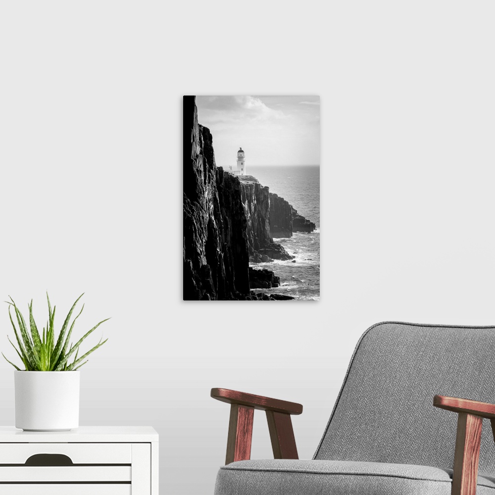 A modern room featuring Fine art photo of a lighthouse at the edge of a cliff by the ocean in black and white.