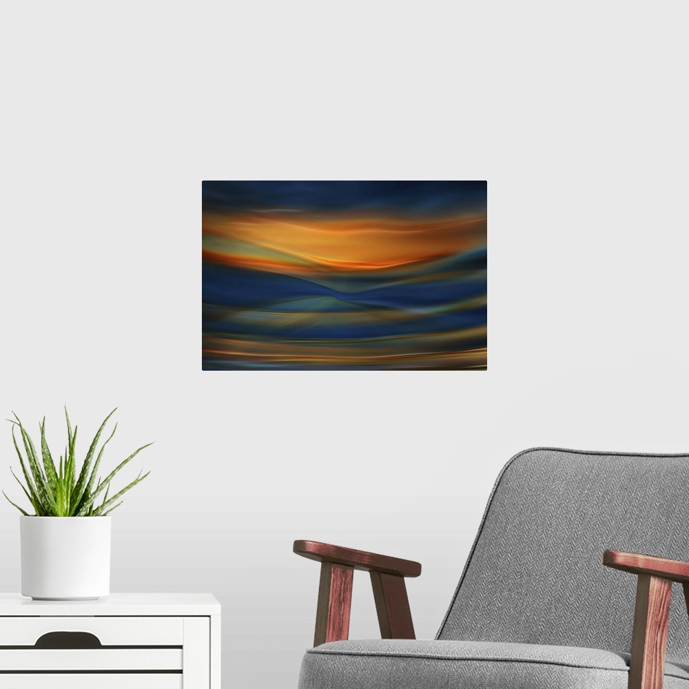 A modern room featuring Abstract photograph of blurred and blended colors and flowing lines in shades of orange and blue.