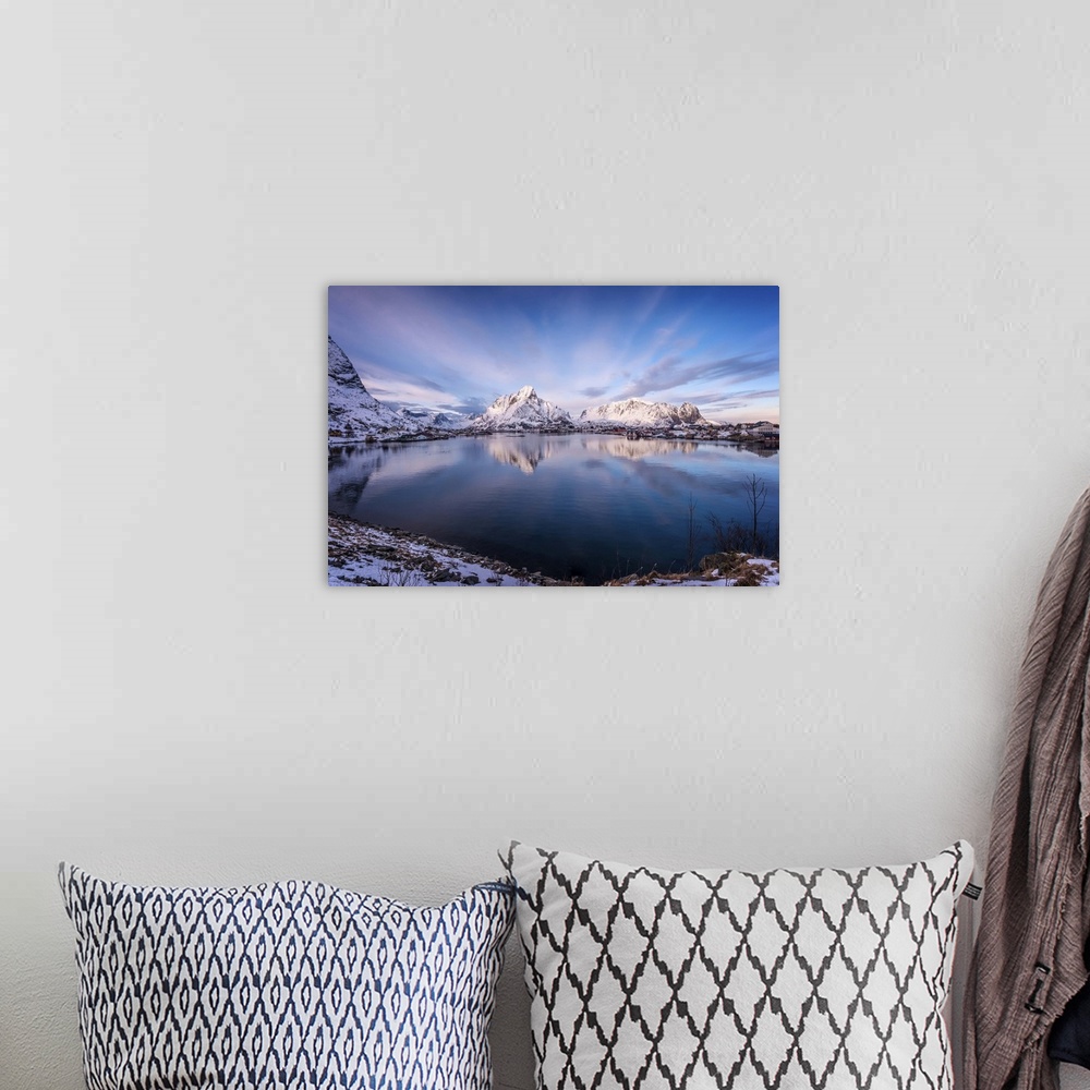 A bohemian room featuring A photograph of snow covered mountains seen from the shore of a lake.
