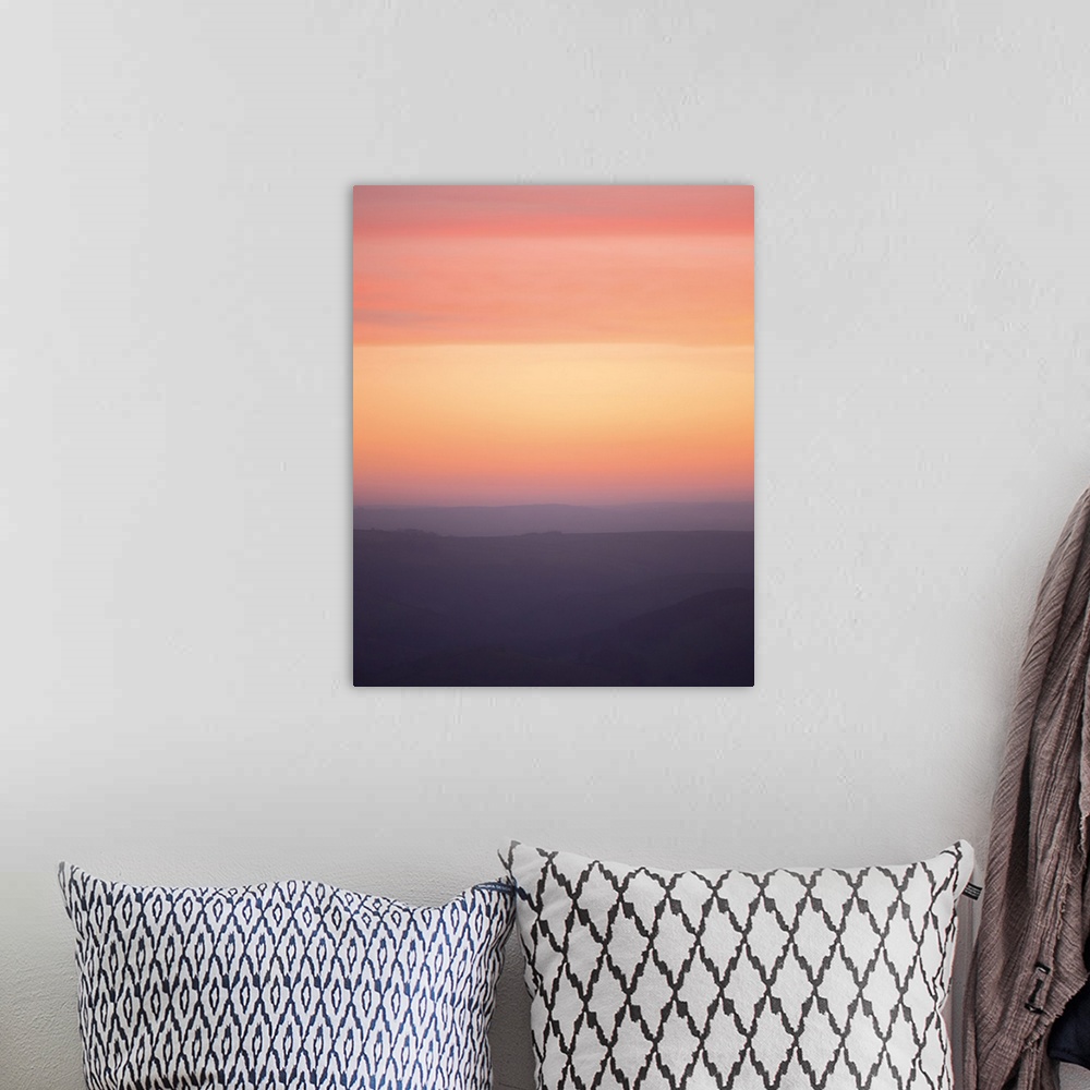 A bohemian room featuring A photograph of a silhouetted hazy landscape under a sunset sky.