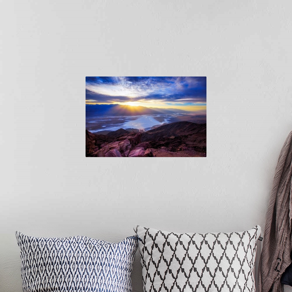 A bohemian room featuring A photo of a sunset over a valley and mountain.