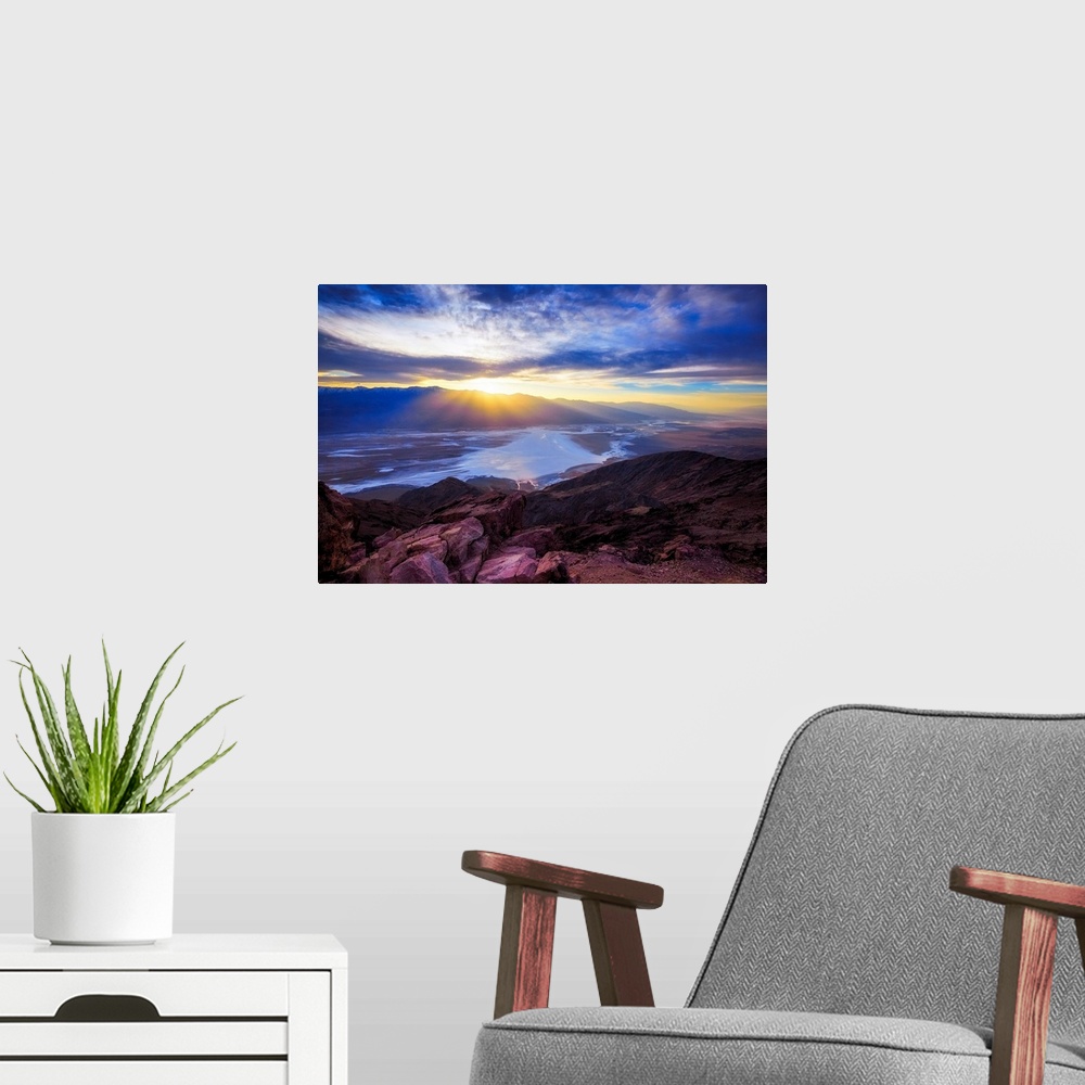 A modern room featuring A photo of a sunset over a valley and mountain.