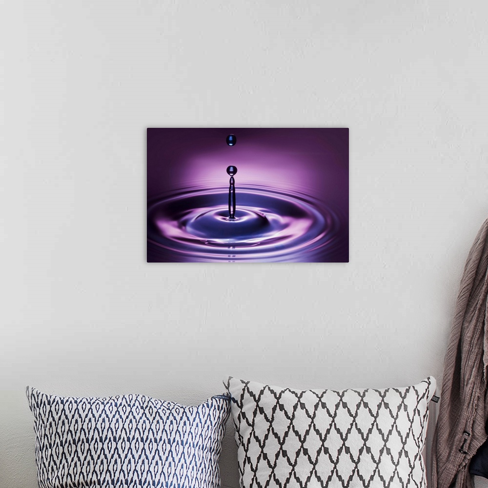 A bohemian room featuring A macro photograph of a water droplet suspended in air after hitting a watery surface.