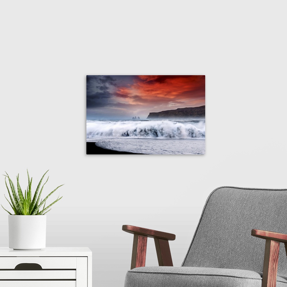 A modern room featuring Photograph of a large crashing wave onto the shore with a bold red sunset above and a crescent mo...