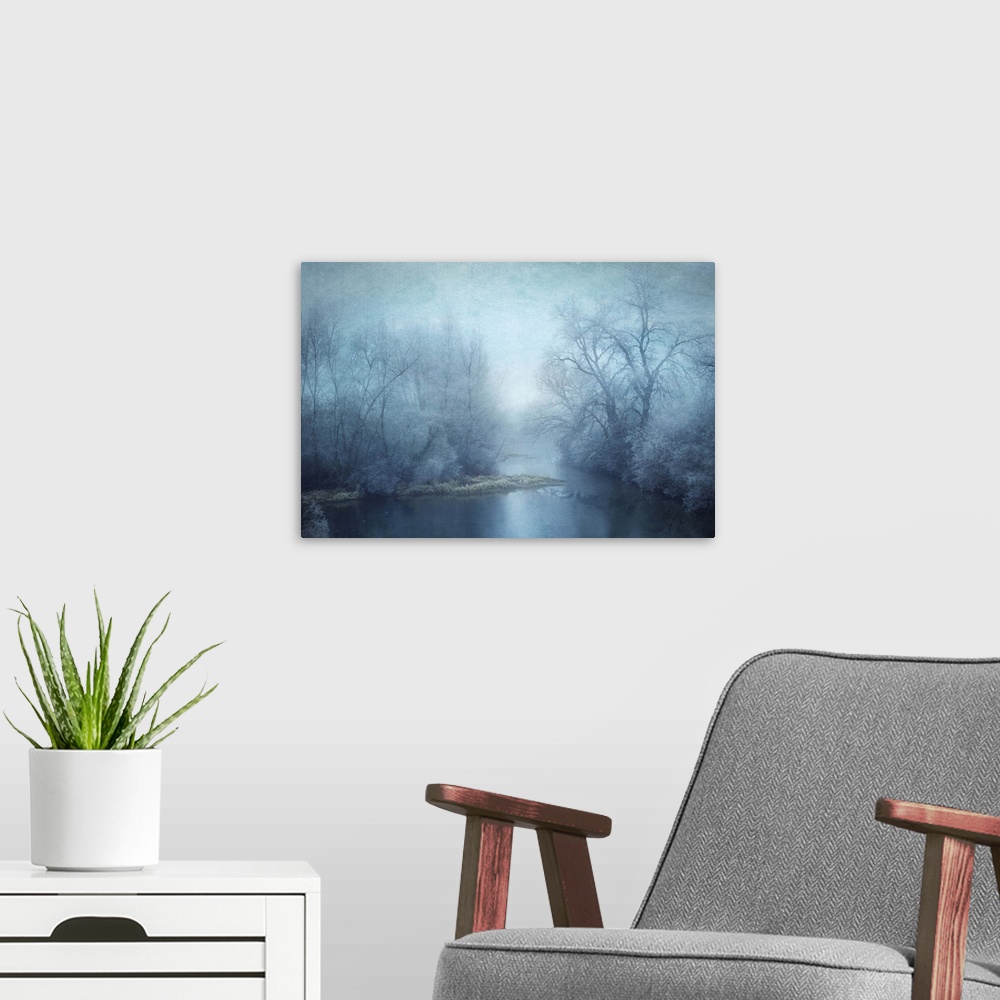 A modern room featuring Blue toned photograph of a calm lake surrounded with winter trees.