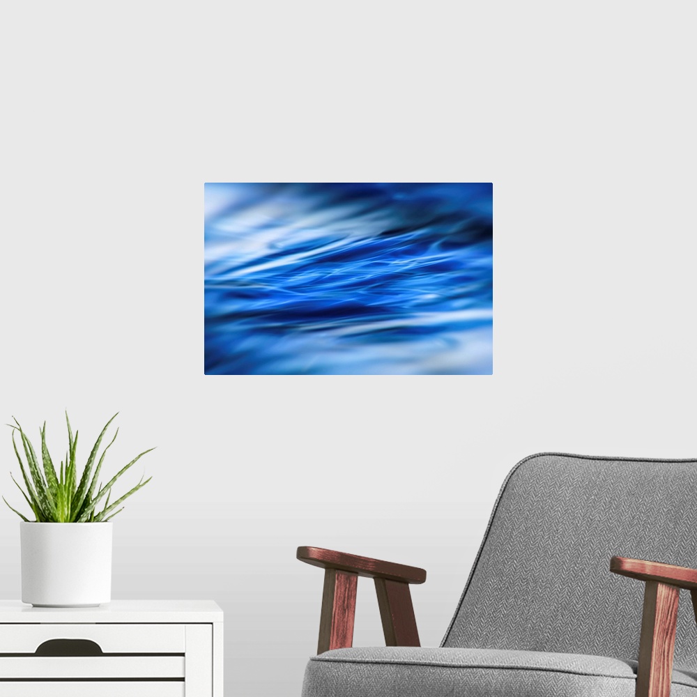 A modern room featuring Abstract photograph of moving blue water with white highlights and a blurred vignette.