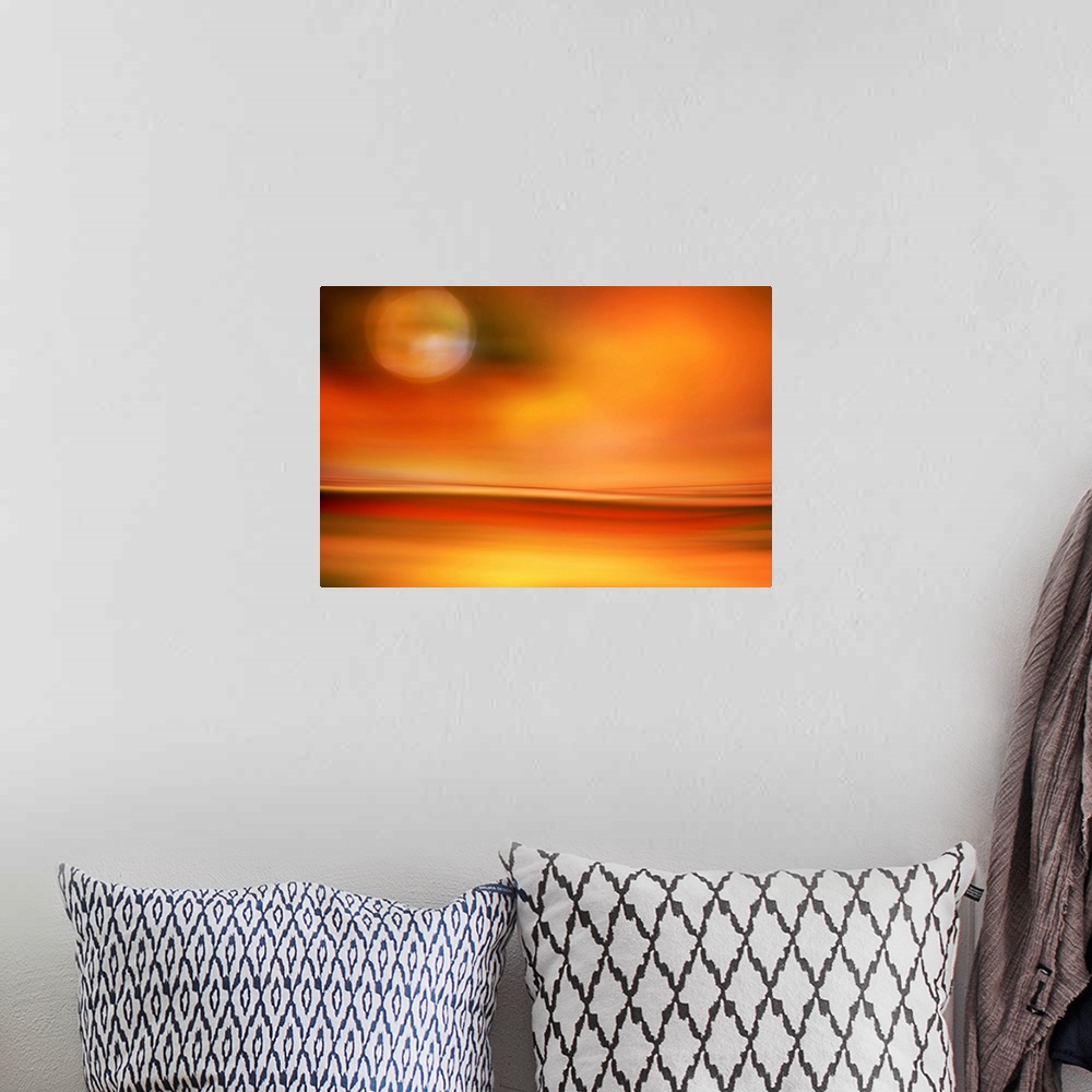 A bohemian room featuring Abstract photo of smooth waves in bright orange tones resembling the moon in the sky over a desert.