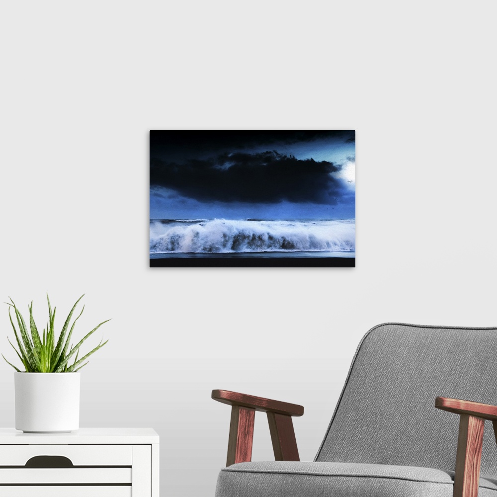 A modern room featuring A photograph of a seascape under a dark cloudy sky.