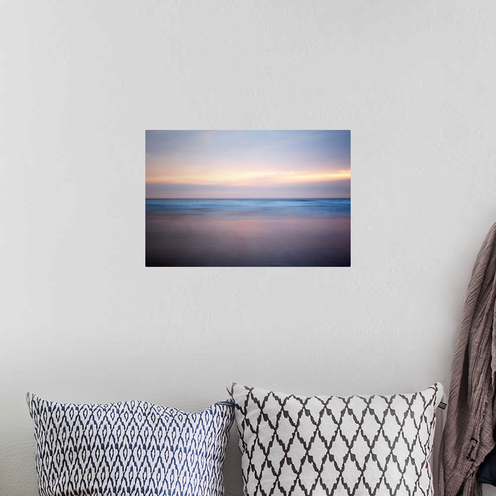 A bohemian room featuring An abstract fine art photograph of a sunrise that has a soft and blurred appearance.