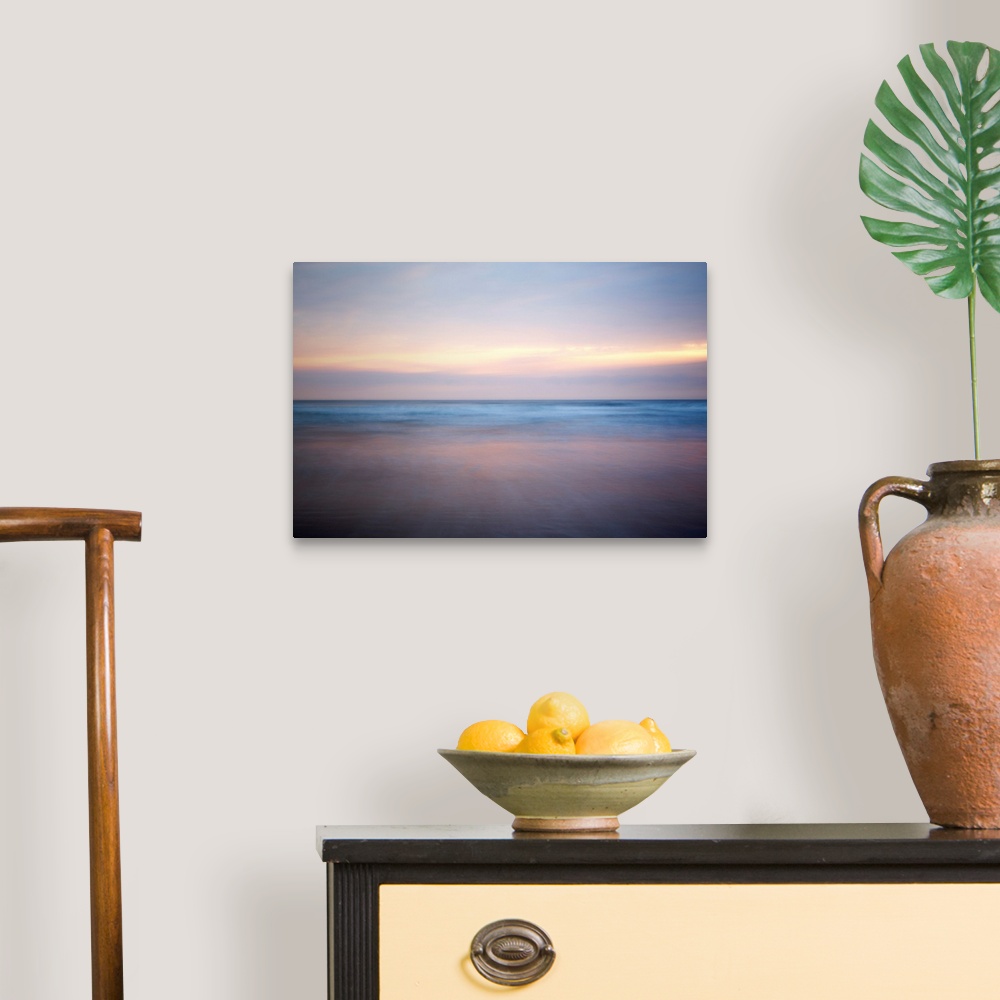 A traditional room featuring An abstract fine art photograph of a sunrise that has a soft and blurred appearance.