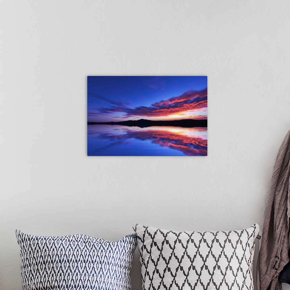 A bohemian room featuring Reflection of a sunset over the sea with mountains in the background
