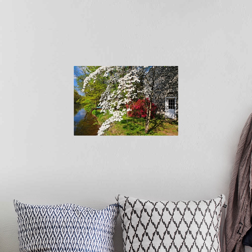 A bohemian room featuring Landscape photograph of spring flowers in bloom next to a stone building and at the edge of the D...