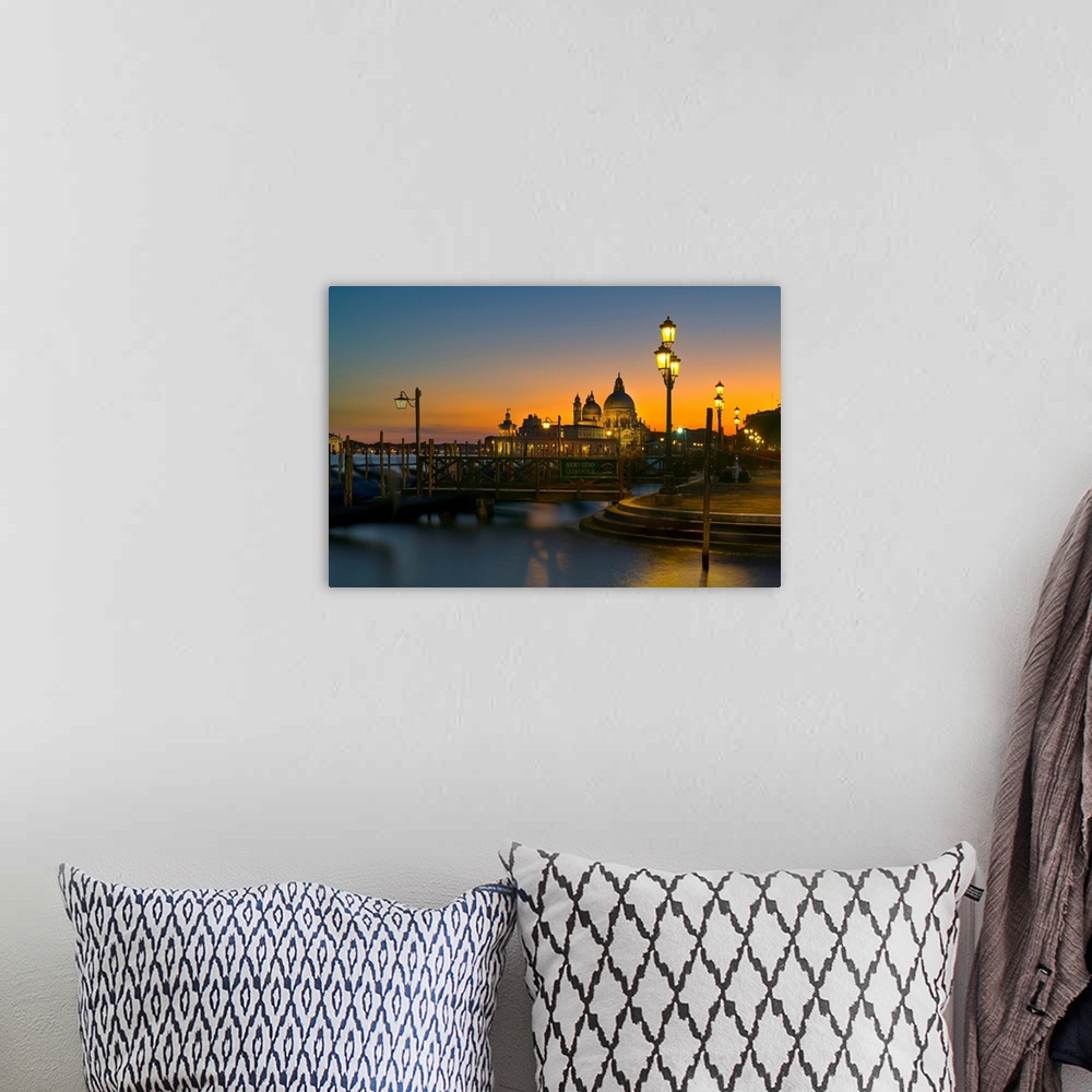 A bohemian room featuring Sunset over Venice, Italy with yellow lit lampposts and calm waters.