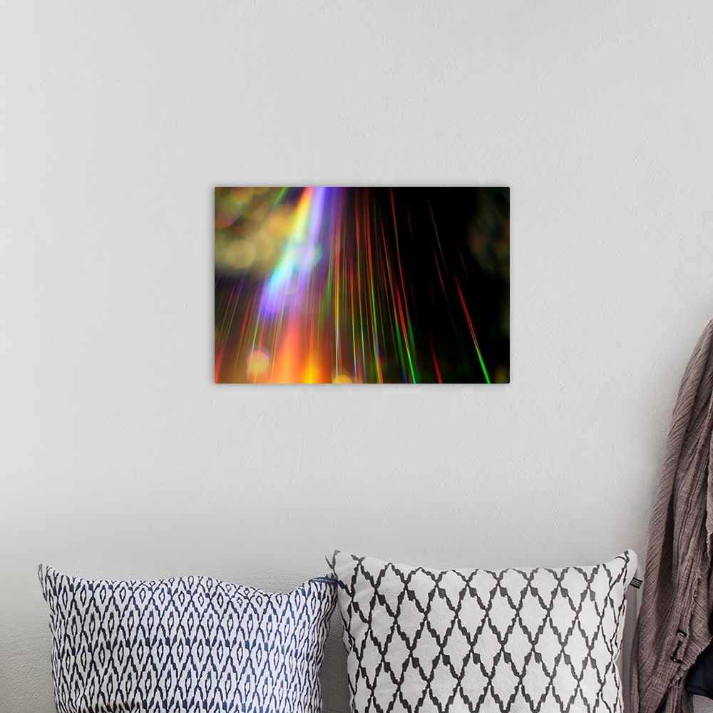 A bohemian room featuring An abstract piece with a rainbow of colors streaking vertically on the print against a black back...