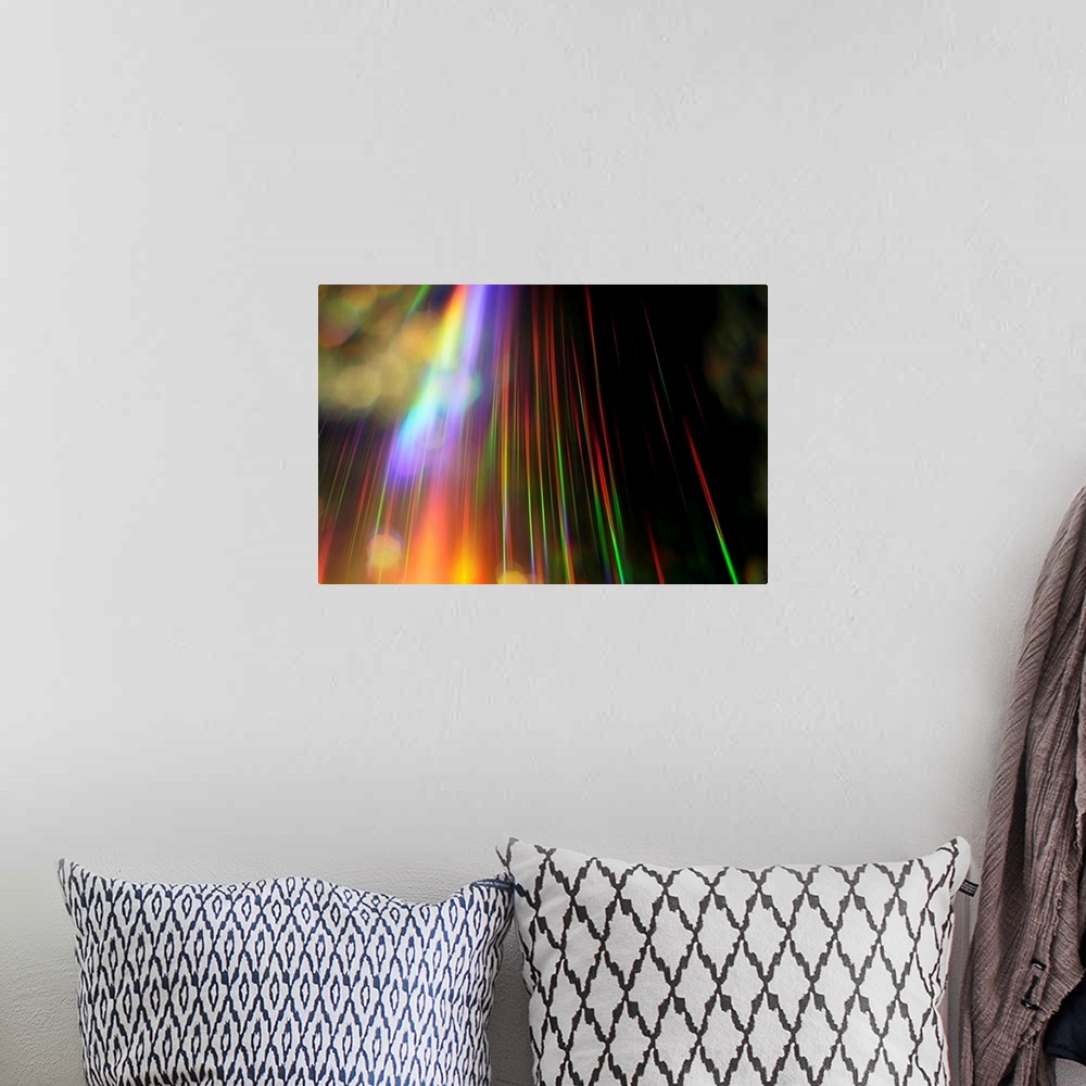 A bohemian room featuring An abstract piece with a rainbow of colors streaking vertically on the print against a black back...