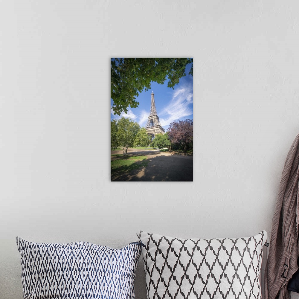 A bohemian room featuring Eiffel tower view from Champ de mars in Paris, France among trees and garden on summer under a bl...