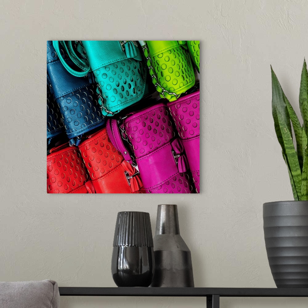 A modern room featuring An assortment of brightly colored leather purses for sale.