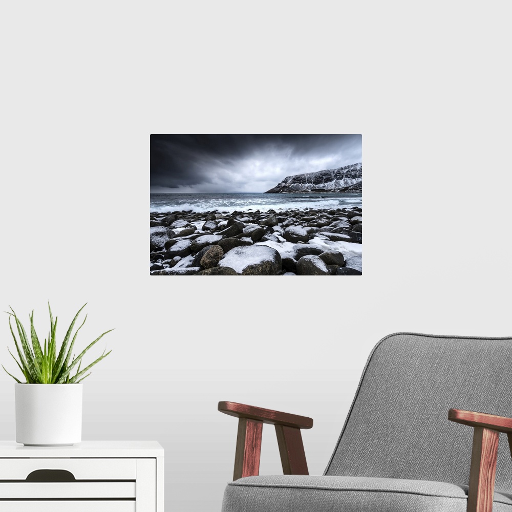 A modern room featuring A photograph of snow covered mountains seen from the shore of a lake.