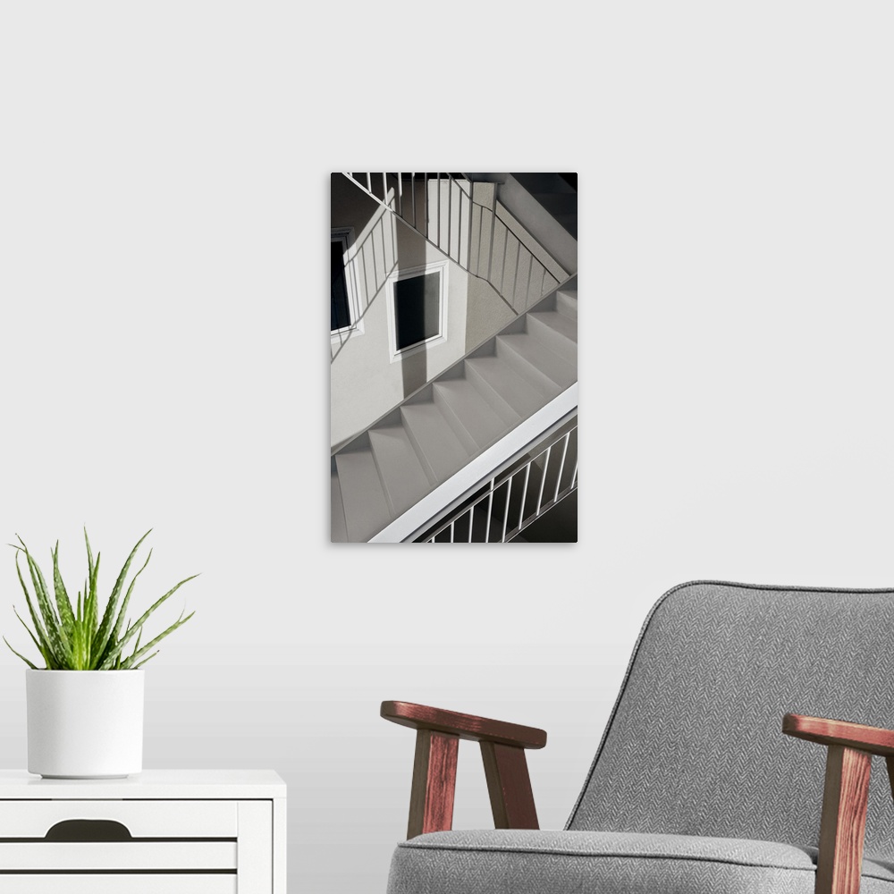 A modern room featuring Monotone image of a stairwell with iron railing casting interesting shadows.