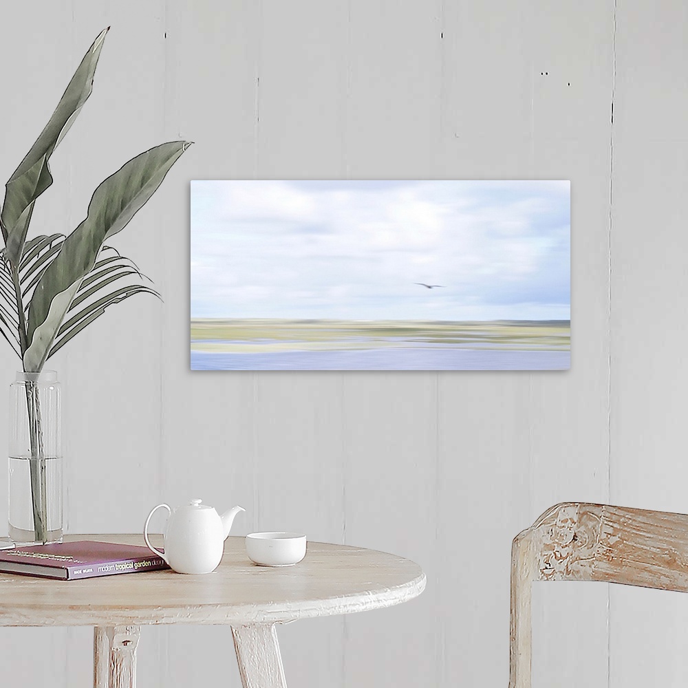 A farmhouse room featuring Artistically blurred photo. The fading colors of summer. A seagull flies over the marshes.