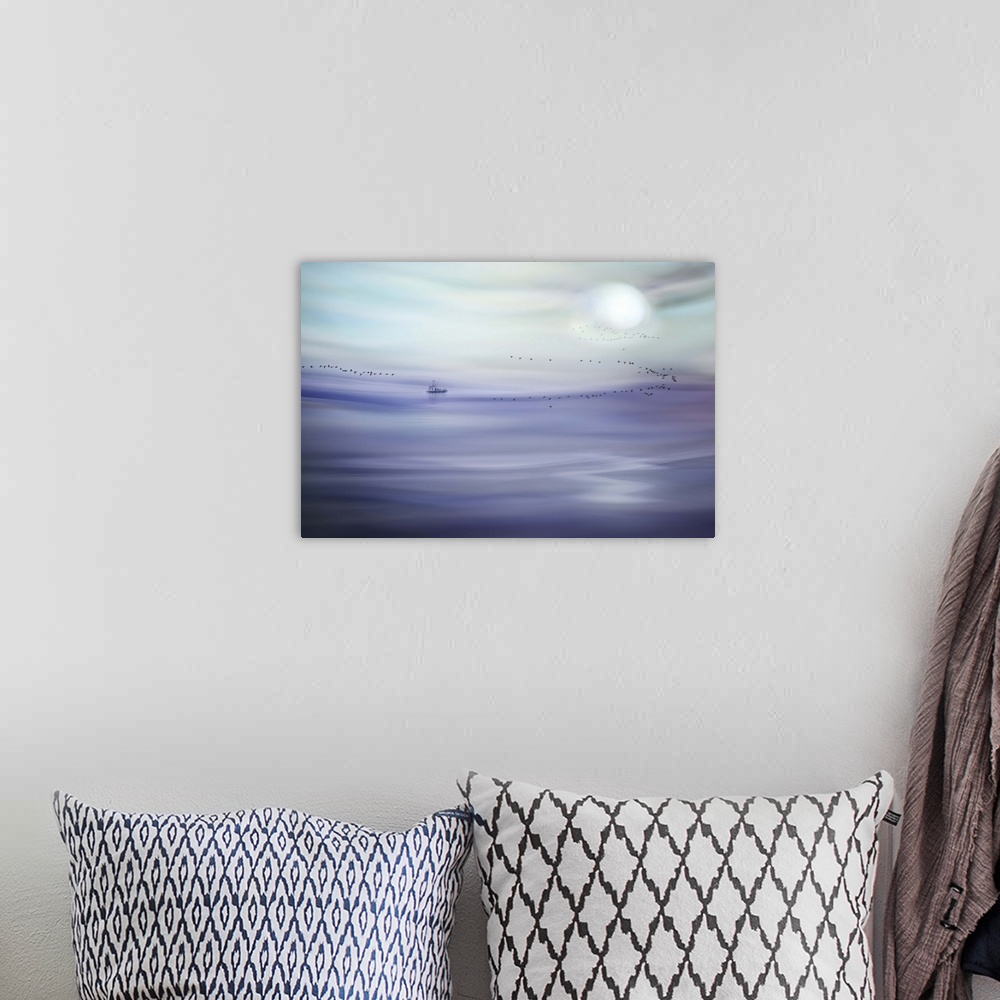 A bohemian room featuring An abstract photograph of a pale purple and blue landscape.