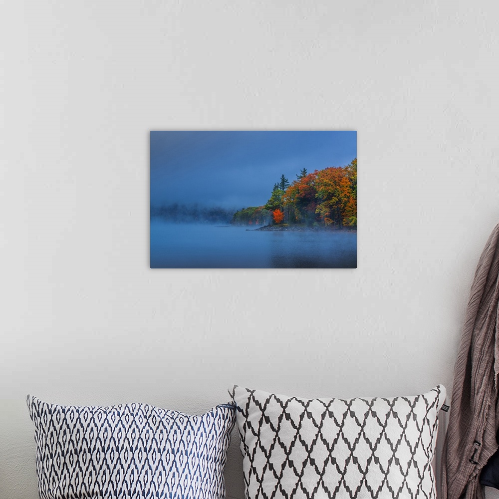 A bohemian room featuring Dense fog over a lake in the evening with autumn trees.