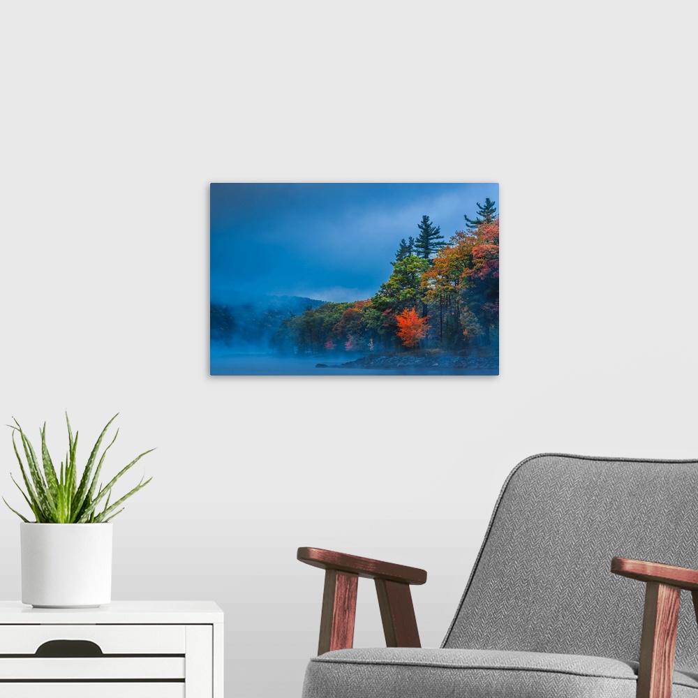 A modern room featuring Dense fog over a lake in the evening with autumn trees.
