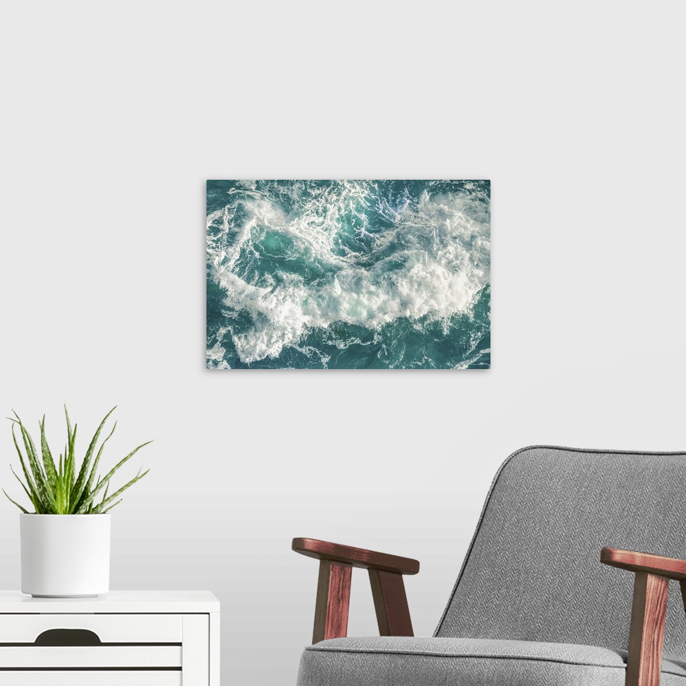 A modern room featuring Birds eye view of  huge green wave crashing on the beach with white foam and droplets.