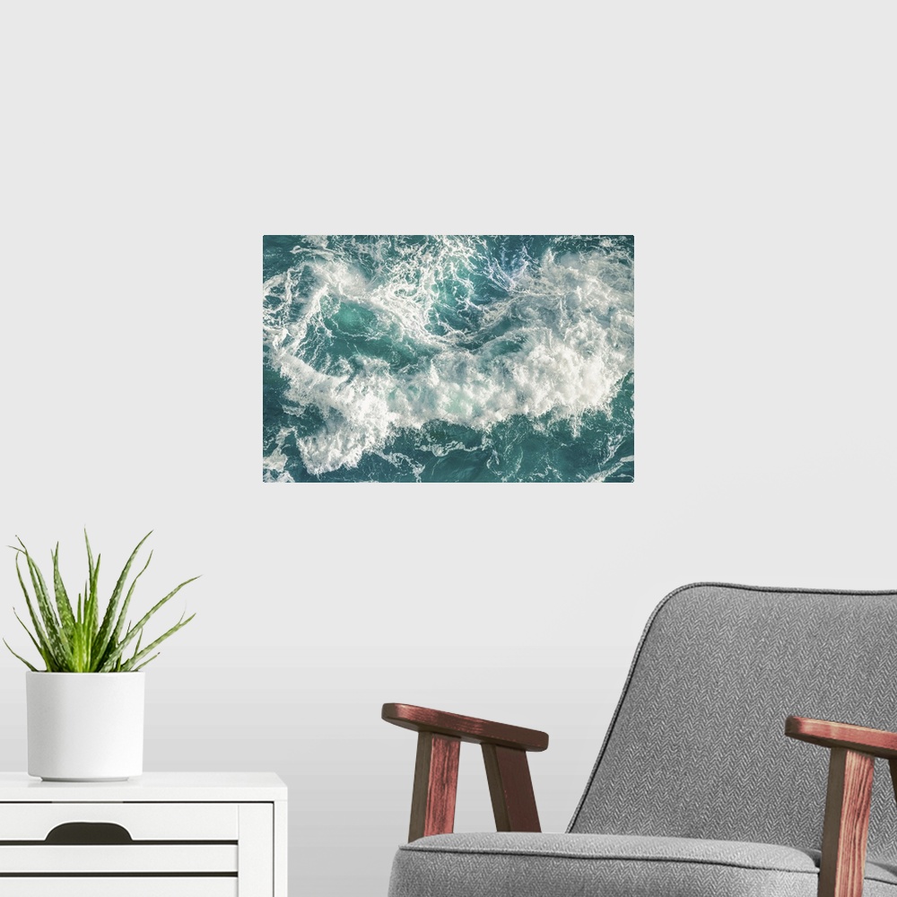 A modern room featuring Birds eye view of  huge green wave crashing on the beach with white foam and droplets.