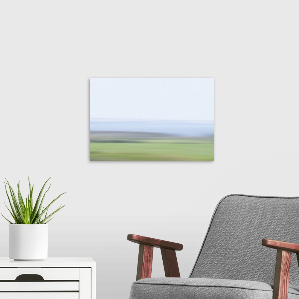 A modern room featuring Artistically blurred photo. Delicate colors of a lake and fields early on a hazy morning.