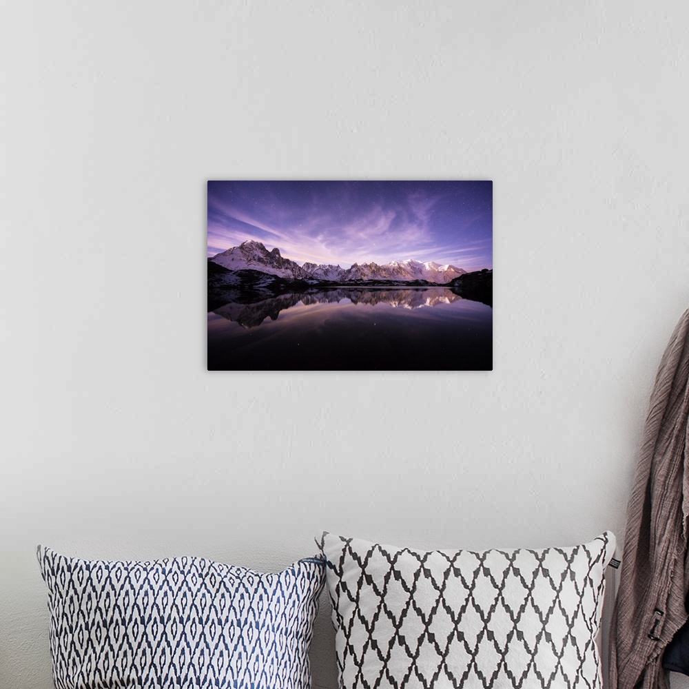 A bohemian room featuring A photograph of the French Alps under a purple sky at dusk.