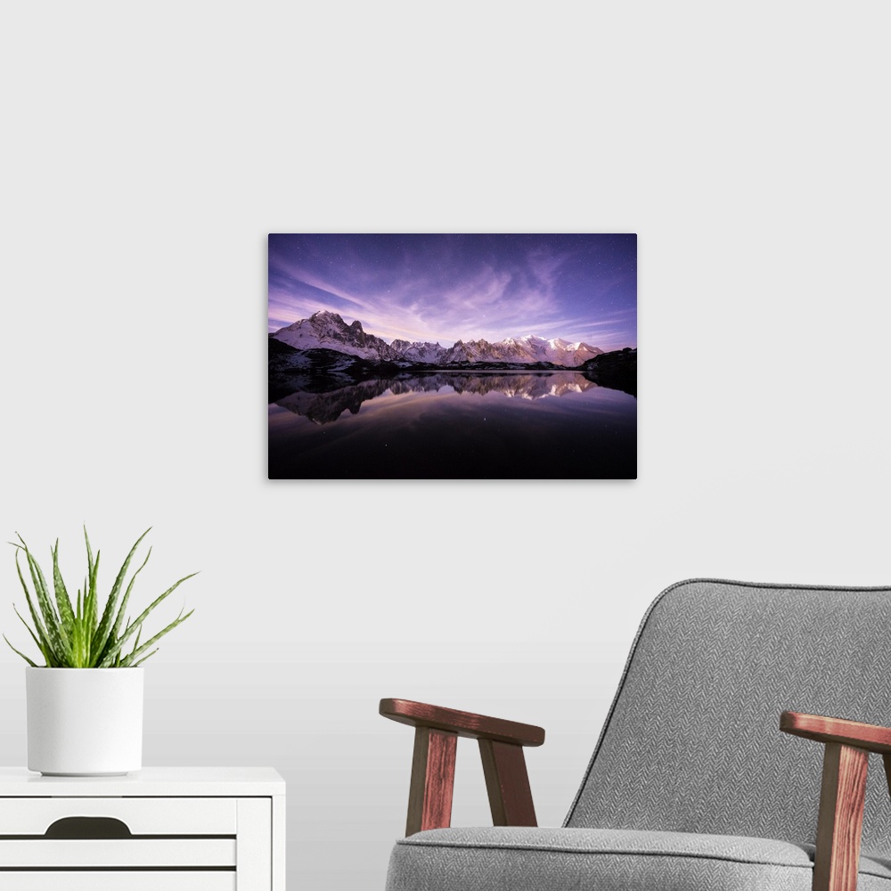 A modern room featuring A photograph of the French Alps under a purple sky at dusk.