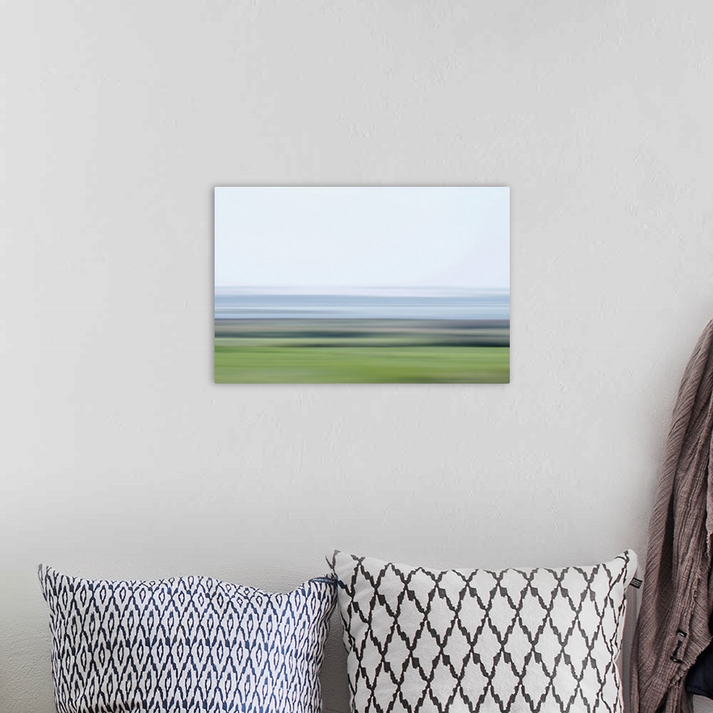 A bohemian room featuring Artistically blurred photo. Frisky colors of a lake and fields early on a cool morning.
