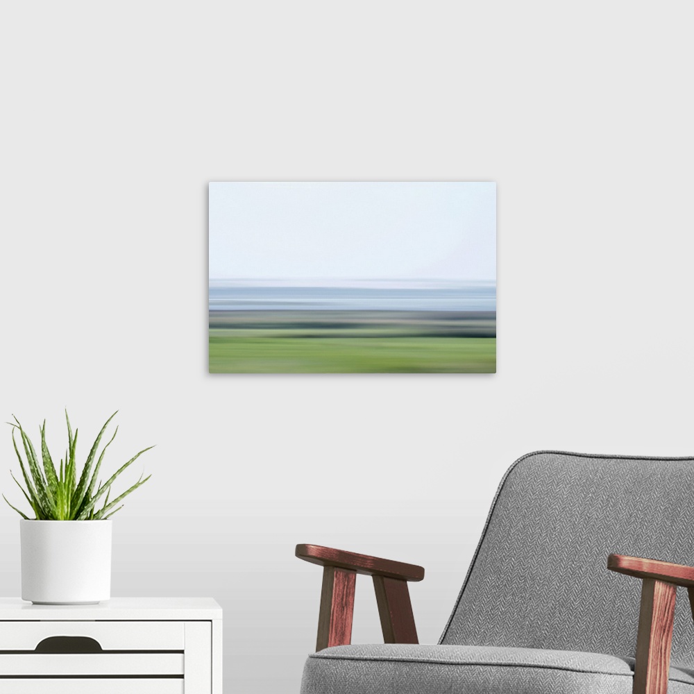 A modern room featuring Artistically blurred photo. Frisky colors of a lake and fields early on a cool morning.