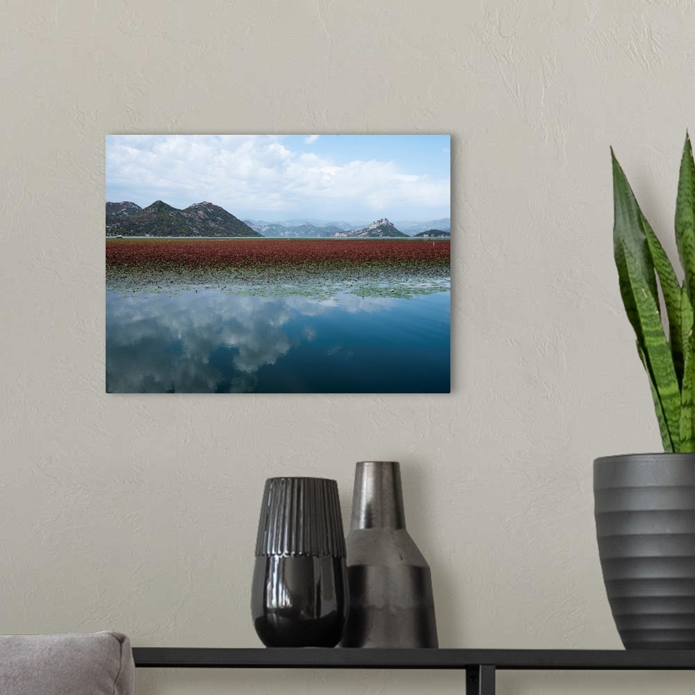 A modern room featuring Photograph of a beautiful landscape with mountains and a lake that is reflecting the white clouds...