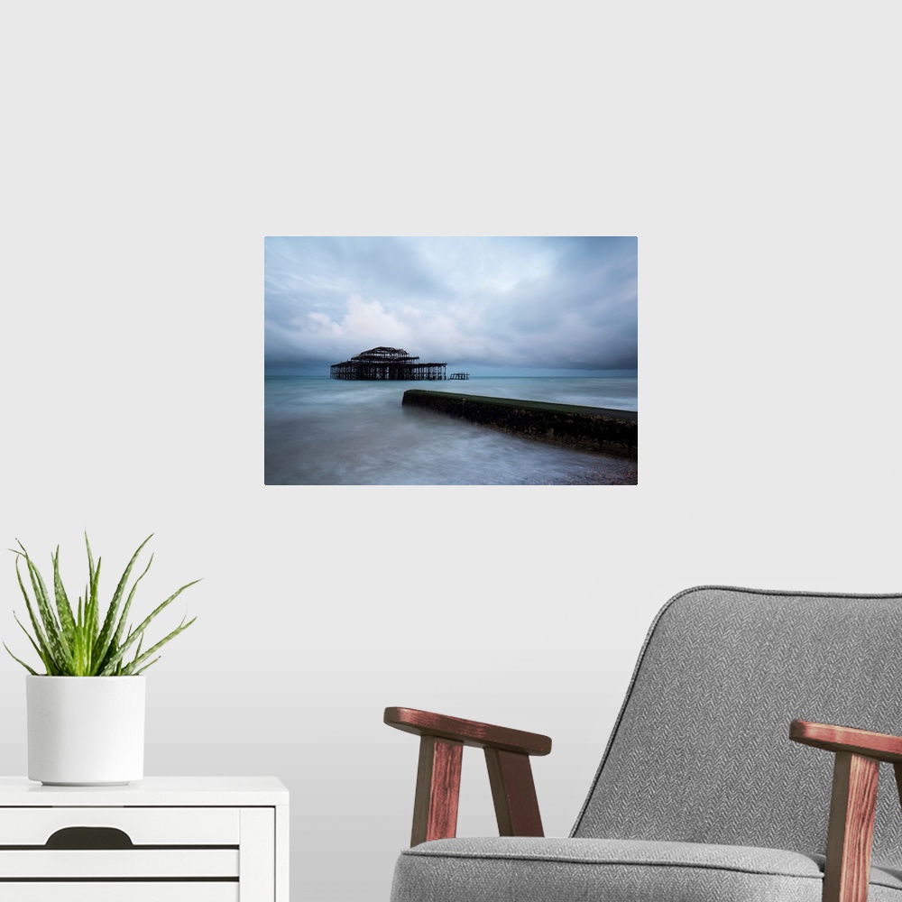 A modern room featuring A cool blue dramatic storm image of Brighton Pier, Sussex, UK with the Old Pier in stormy seas an...