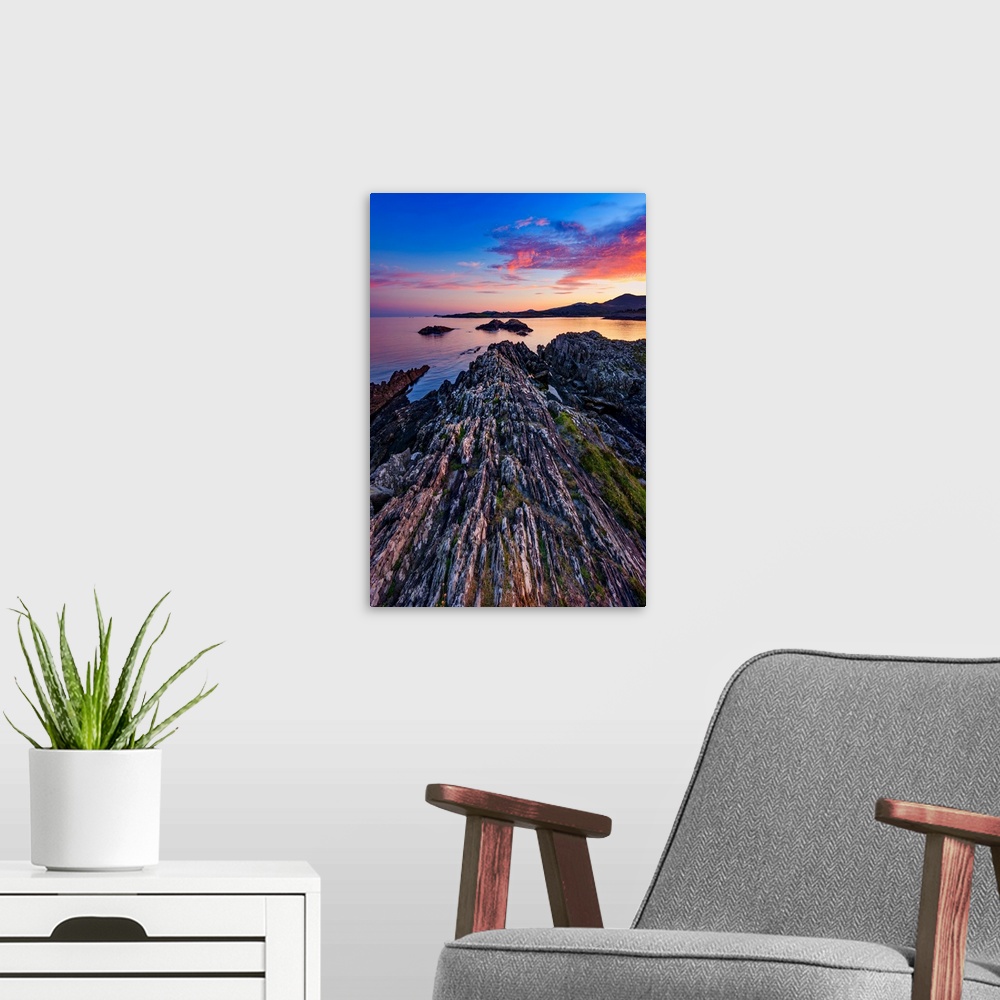 A modern room featuring Sunset over the sea in Ireland with rocks in the foreground