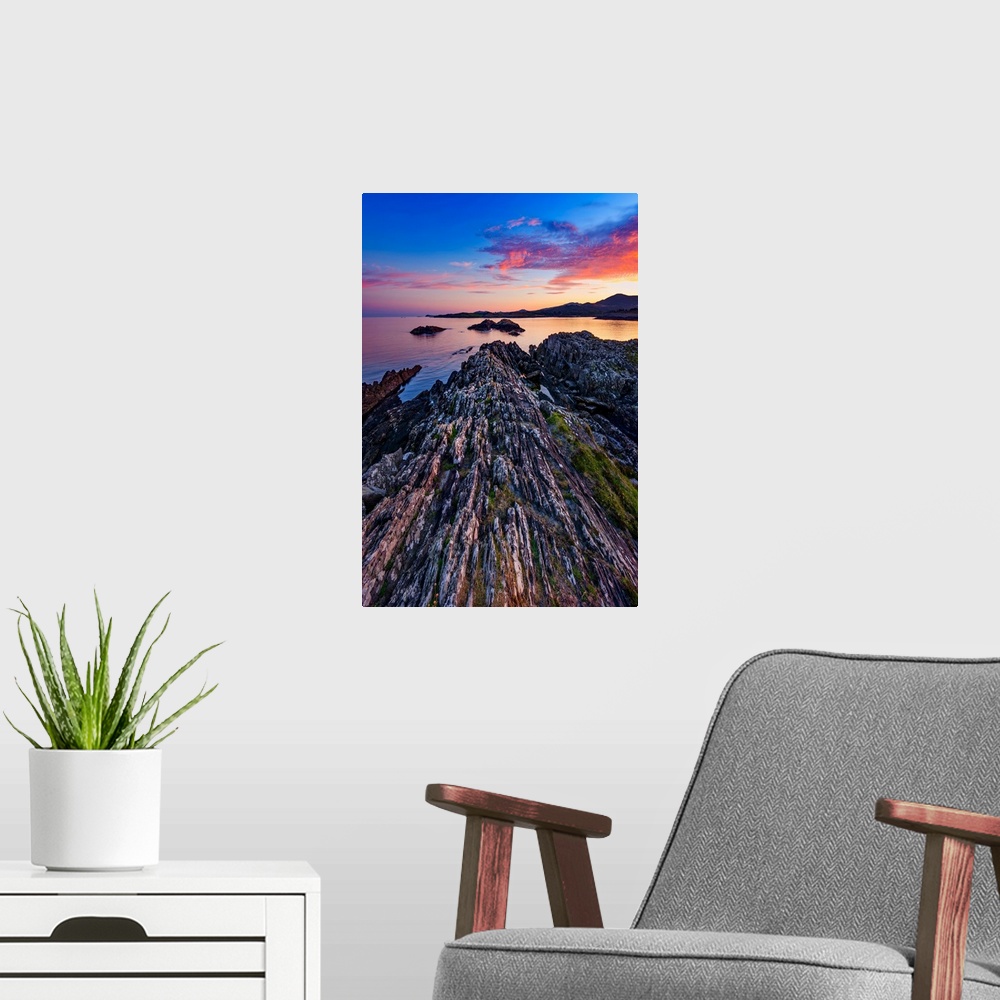 A modern room featuring Sunset over the sea in Ireland with rocks in the foreground