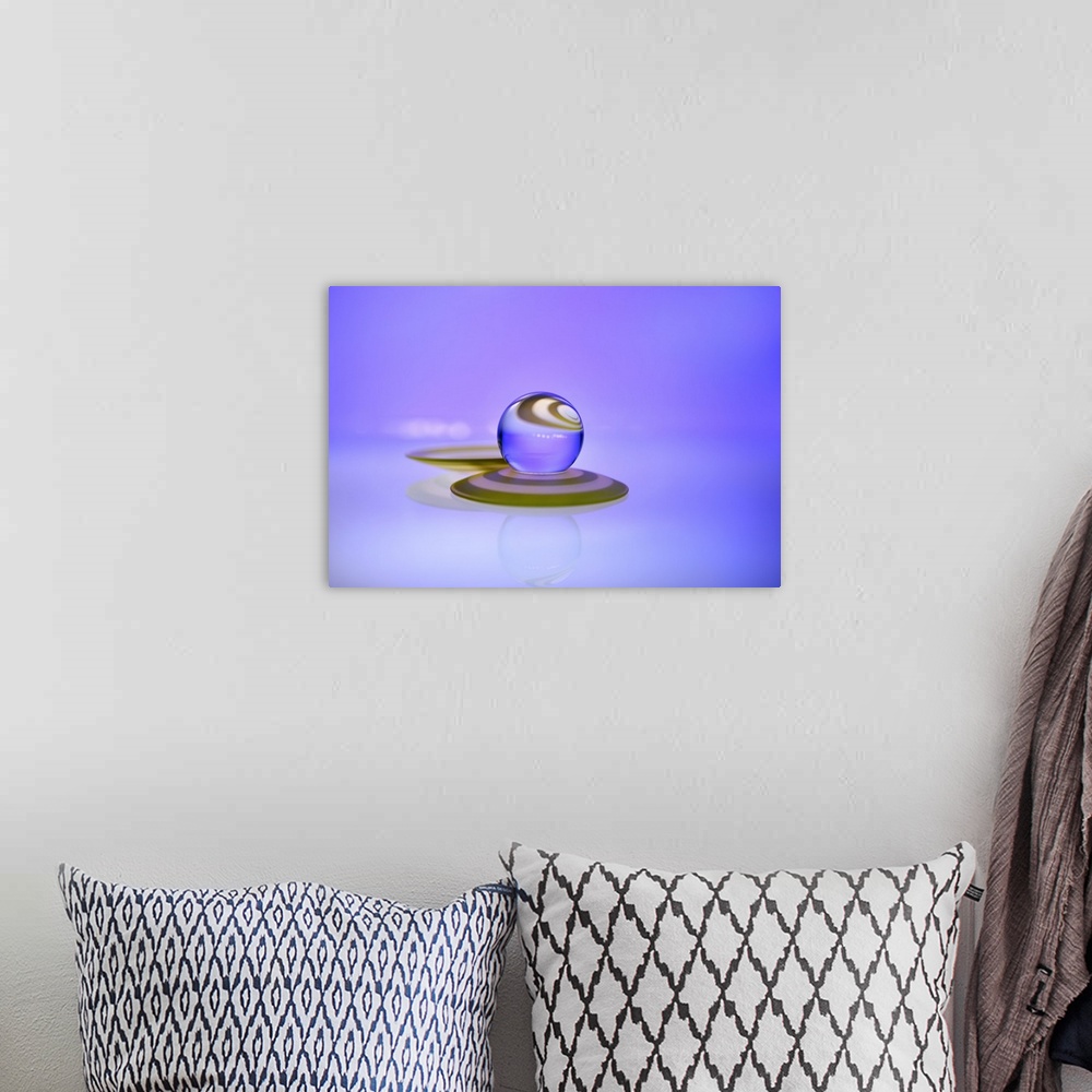 A bohemian room featuring A macro photograph of a water droplet sitting on top purple surface against a purple background.